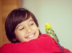 Kid playing with his pet parrot
