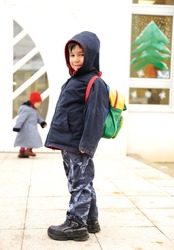 Little cute preschool child with bag on his back