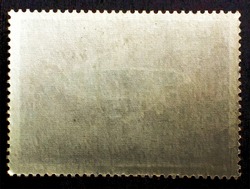 Old grunge posted stamp reverse  side with the edge of the sheet. Texture of paper. 
