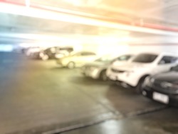 Abstract blurred image of car in parking area at office building.