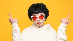Portrait Happy Woman Smiling Dancing to Music Rhythmically to Beat Moving her Hands in Yellow Sweater Yellow Background Slow Motion in Sunglasses . Monotone. Positive Emotions of People. Freedom. Life