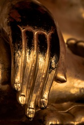 A hand of a sitting Buddha statue in a public Buddhist temple in Bangkok, Thailand
