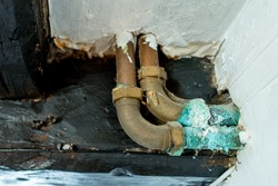 Shallow focus of a leaking hot water pipe showing the copper sulphate scale around the joint. Seen in an old house.