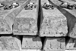Monochrome view of stacked concrete railway sleepers showing the centre steel rods to aid in the strength of the sleepers.