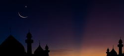 Silhouette dome mosques and crescent moon on dusk sky twilight in the evening religion of Islamic on Ramadan Kareem, Eid Al Fitr, Eid Al Adha and free space for text arabic 