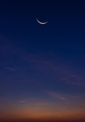Crescent moon on dusk sky vertical Twilight after sundown symbol of religion islamic in Ramadan Kareem month space for text Eid al Adha, Eid Al Fitr