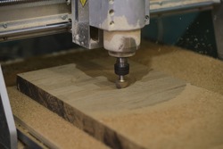 Milling a wooden board. Processing of wood panels on CNC coordinate milling woodworking machines. Slow motion video. Sawdust scatter in different directions