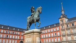 Plaza Mayor - Bright Autumn sunlight shines on the bronze equestrian statue of Philip III standing at the center of Plaza Mayor, Madrid, Spain.