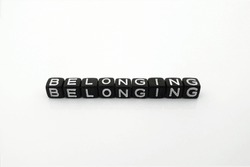 Belonging symbol , isolated on white background and copy space. Belonging word on black cubes lettering. Diversity, equality, inclusion and belonging business concept.