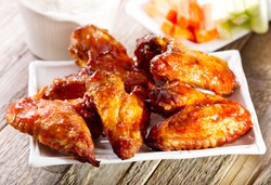 plate of chicken wings on wooden table