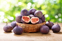 basket of fresh ripe figs fruit on a wooden table
