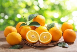 fresh orange fruits with leaves on wooden table