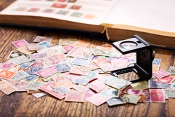 Old postage stamps from various countries on wooden table