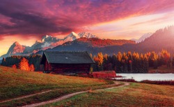 Majestic Colorful sunset with dramatic sky over alpine valley. Fairytale lake Geroldsee and pine trees under sunlihgt. Awesome alpine highlands in sunny day. Amazing autumn landscape. Awesome nature.