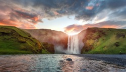 Icelandic Landscape. Classic long exposure view of famous Skogafoss waterfall with colorful sky during sunset. Skoga river, highlands of Iceland, Europe. Popular Travel destinations. Amazing nature