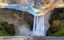 Majestic nature of Iceland. Impressively View on Skogafoss Waterfall with colorful sky glowing sunlight, during sunrise. Skogafoss the most famous place of Iceland. creative artistic image. postcard