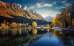 Great nature scenery in Slovenian Alps. Incredible autumn landscape on Jasna lake. Triglav national park. Kranjska Gora, Slovenia. Amazing  landscape with mountain lake and colorful trees at sunset