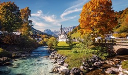 Beautiful nature landscape. Incredible autumn scenery. Scenic mountain landscape in the Bavarian Alps. Small church on the river bank.view on famous Parish Church of St. Sebastian