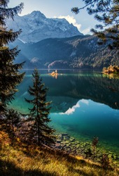 Nature sunny landscape. Dramatic Picturesque scene. The Alps reflected in water at sunset. Alpine landscape. Impressive autumn Landscape. View of Zugspitze from Eibsee, Garmisch-Partenkirchen, Germany