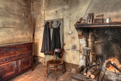 old times farmhouse - interior of an old country house with fireplace, kitchen cupboard, ancient mantles and straw broom