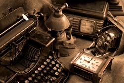 Vintage still life with old typewriter, retro camera and radio receiver in brown colors
