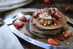 Healthy Concept: Buckwheat Pancakes with Nut butter, Honey, Buckwheat Seeds, goji berries and Fresh Strawberries