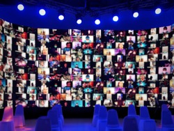 Blur large LED screen show many people's faces join big online event or virtual reality live conference. Video conference, Work from home, Social distancing, New normal event production. 