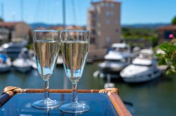 Summer party with sparkling champagne wine and sail boats haven of Port Grimaud on background, Var, Provence, France