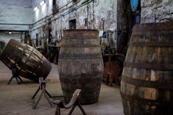 Old porto lodge with rows of oak wooden casks for slow aging of fortified ruby or tawny porto wine in Vila Nova de Gaia, north of Portugal