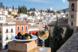 Tasting of Spanish sweet and dry fortified Vino de Jerez sherry wine and olives with view on roofs and houses of old andalusian town, South of Spain