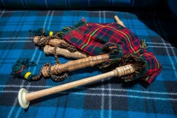 Symbols of Scotland - wollen tartan textile and handmade musical instrument bagpipes, close up