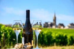 Glasses of white wine from vineyards of Pouilly-Fume appelation and example of flint pebbles soil, near Pouilly-sur-Loire, Burgundy, France.