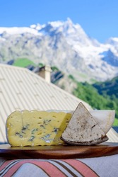 Cheese collection, Tomme de Savoie and Bleu de Savoie blue cheese from Savoy region in French Alps, mild cow's milk cheese served outdoor, mountains view in La Grave village, France