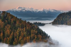 Golden autumn in the mountains with morning mists and yellow-red leaves on the trees