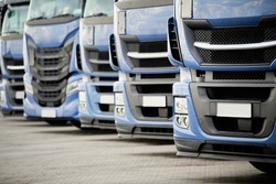 Fleet of commercial lorry trucks in row. Logistics and transportation service