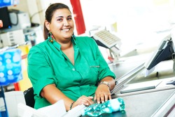 Portrait of seller assistant or cashdesk cashier worker teller in supermarket store