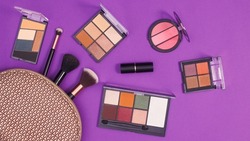 Make up kit with make up products on purple background. Flat lay