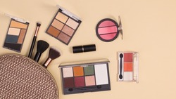 Make up kit with make up products on pastel beige background. Flat lay