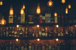 Soft focus picture of vintage lamps with blurred liquor bar in Vintage photo filter style.
