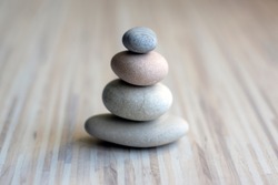 Stone cairn on striped grey white background, three stones tower, simple poise stones, simplicity harmony and balance, rock zen sculptures