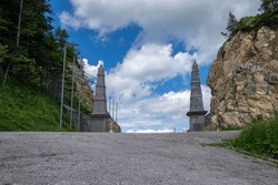Ljubelj pass in Karawanks chain in Gorenjska region of Slovenia wihh a passageway with two tall stone obelisk on the border between Slovenia and Austria in summer time 