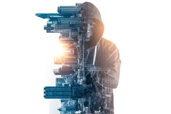 The abstract image of the hacker standing overlay with futuristic hologram and the future cityscape is backdrop. the concept of cyber attack, virus, malware, illegally and cyber security.