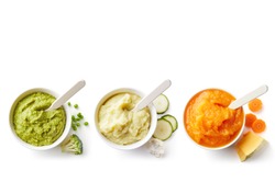 Green, yellow and orange baby puree in bowl isolated on white background, top view