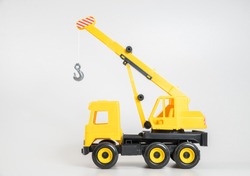 Plastic car. Toy model isolated on a white background. Yellow truck mounted crane.