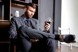 Businessman wearing in suit. Businessman drinking red wine and thinking about business.