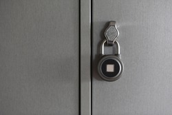 fingerprint padlock is locked and hanging on cell of storage locker in hostel