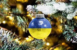New Year's glass ball with the flag of Ukraine against a colorful Christmas background
