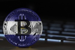 Bitcoin close-up on keyboard background, the flag of El Salvador is shown on bitcoin.