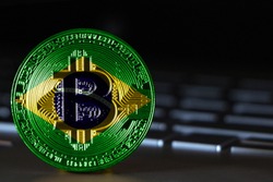 Bitcoin close-up on keyboard background, the flag of Brazil is shown on bitcoin.