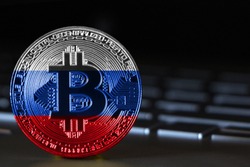 Bitcoin close-up on keyboard background, the flag of russia is shown on bitcoin.